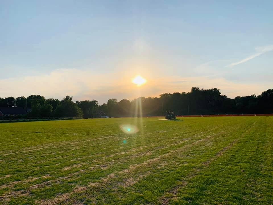 Sunrise over a freshly mown grass field